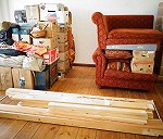 unas 28 cajas de cartón, tablas de madera, sofa, un arcón de madera y una pequenya comóda